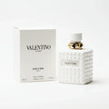 Valentino perfume bottle and packaging on a marble surface with a dark background